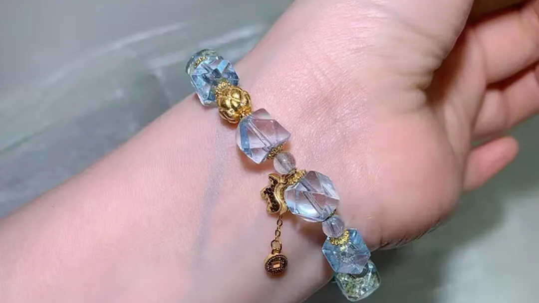 戴在手腕上的天然蓝托帕手链,刻面冰川蓝珠子闪烁光芒