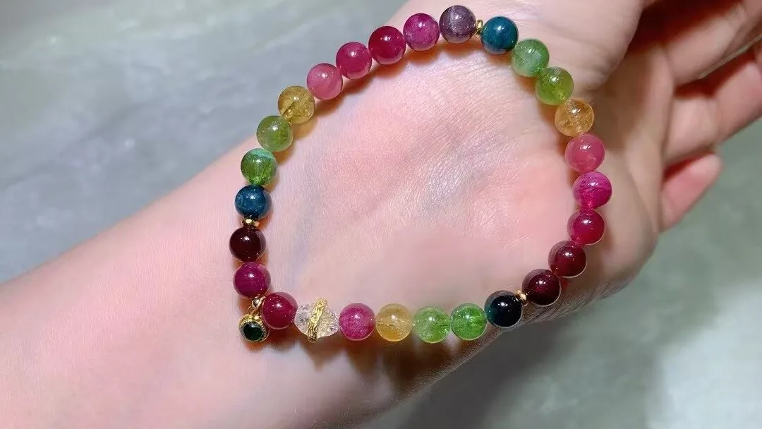 戴在手腕上的天然糖果碧玺手串,粉、红、绿、黄、蓝色珠子